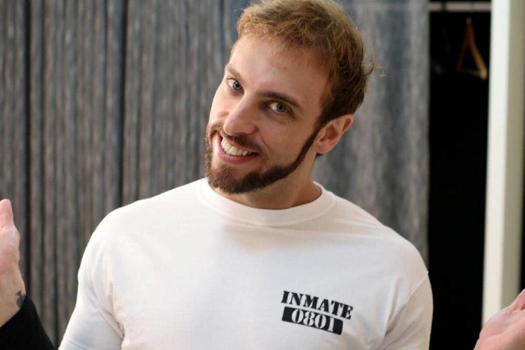 Léo Lins de camisa branca, braços abertos