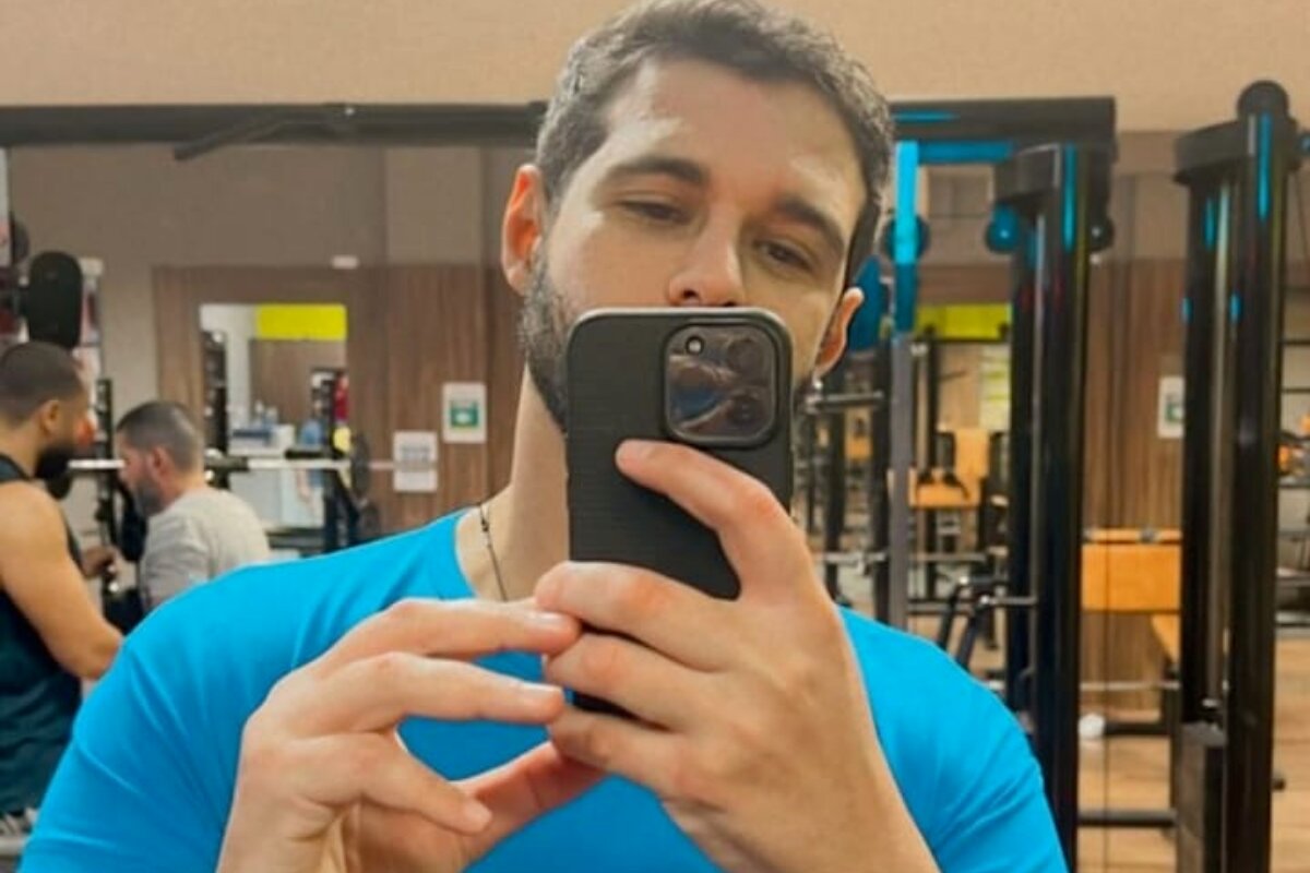 Rodrigo Mussi de camisa azul, fazendo selfie na academia