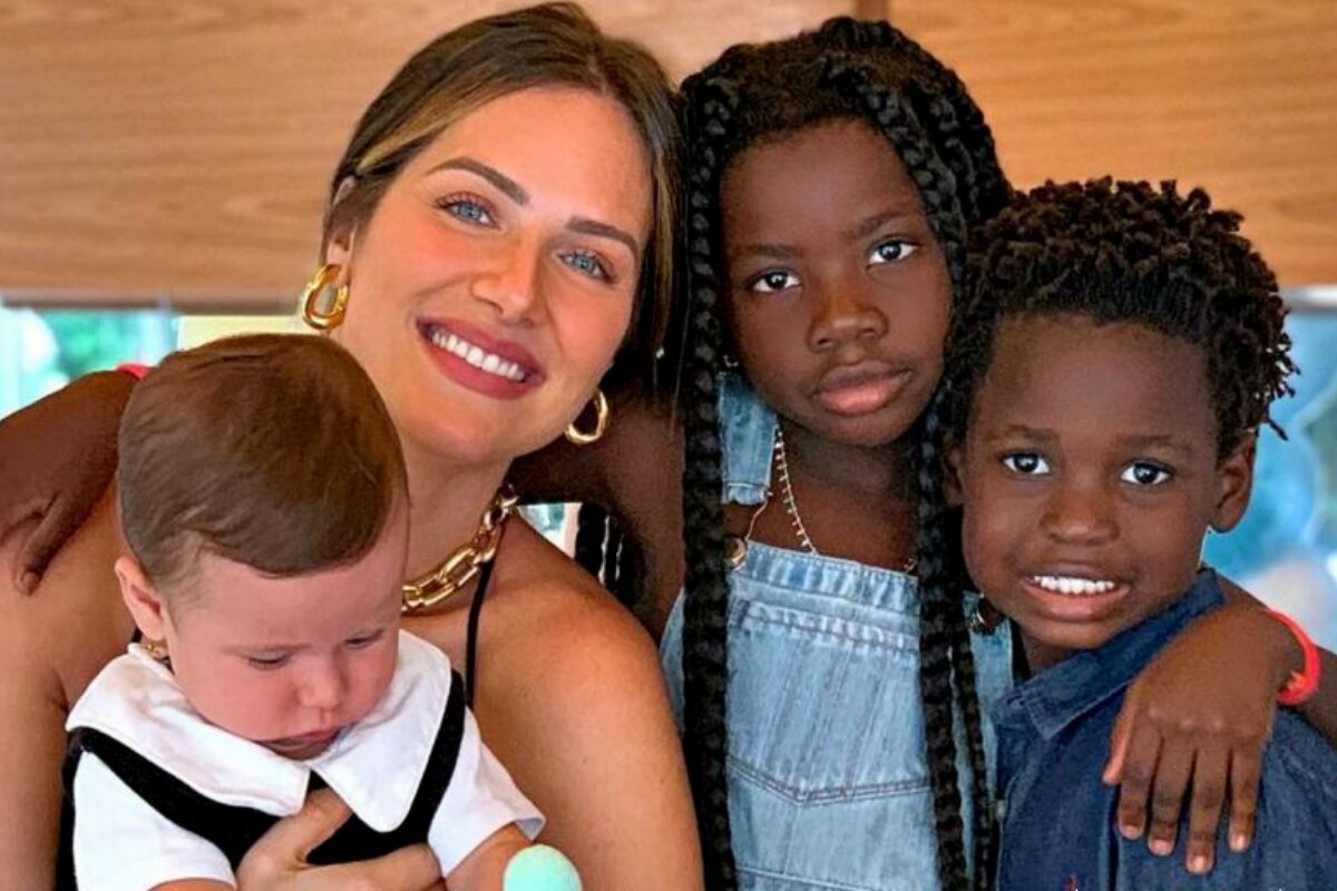 Giovanna Ewbank e os três filhos, sentados e abraçados