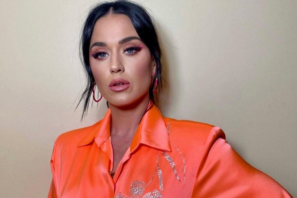 Katy Perry de look laranja, cabelo preto preso