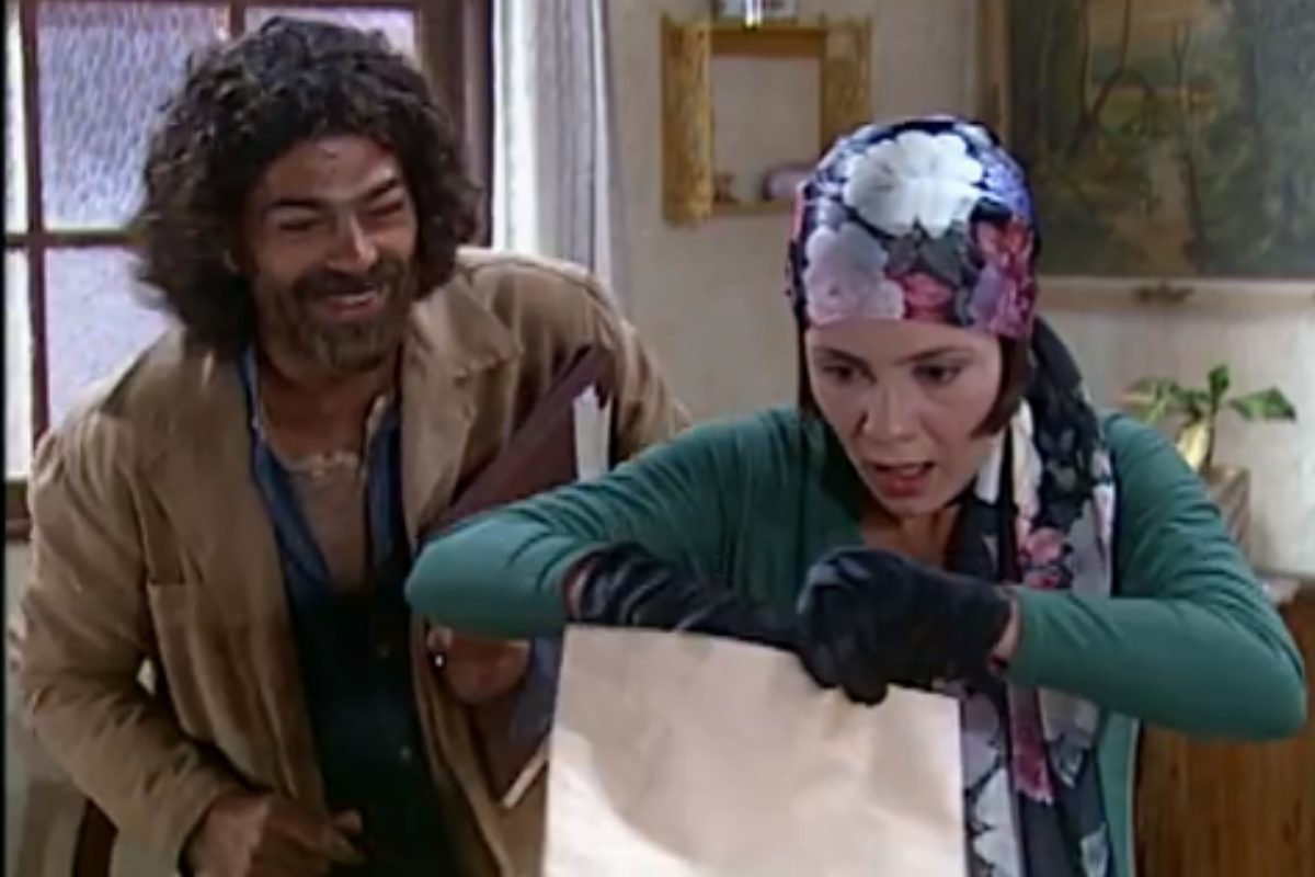 Petruchio (Eduardo Moscovis) e Catarina (Adriana Esteves) acham envelope em O Cravo e a Rosa
