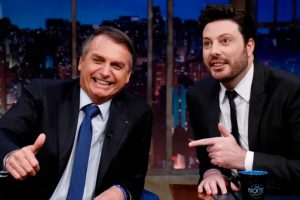 Jair Bolsonaro sentado, sendo entrevistado por Danilo Gentili