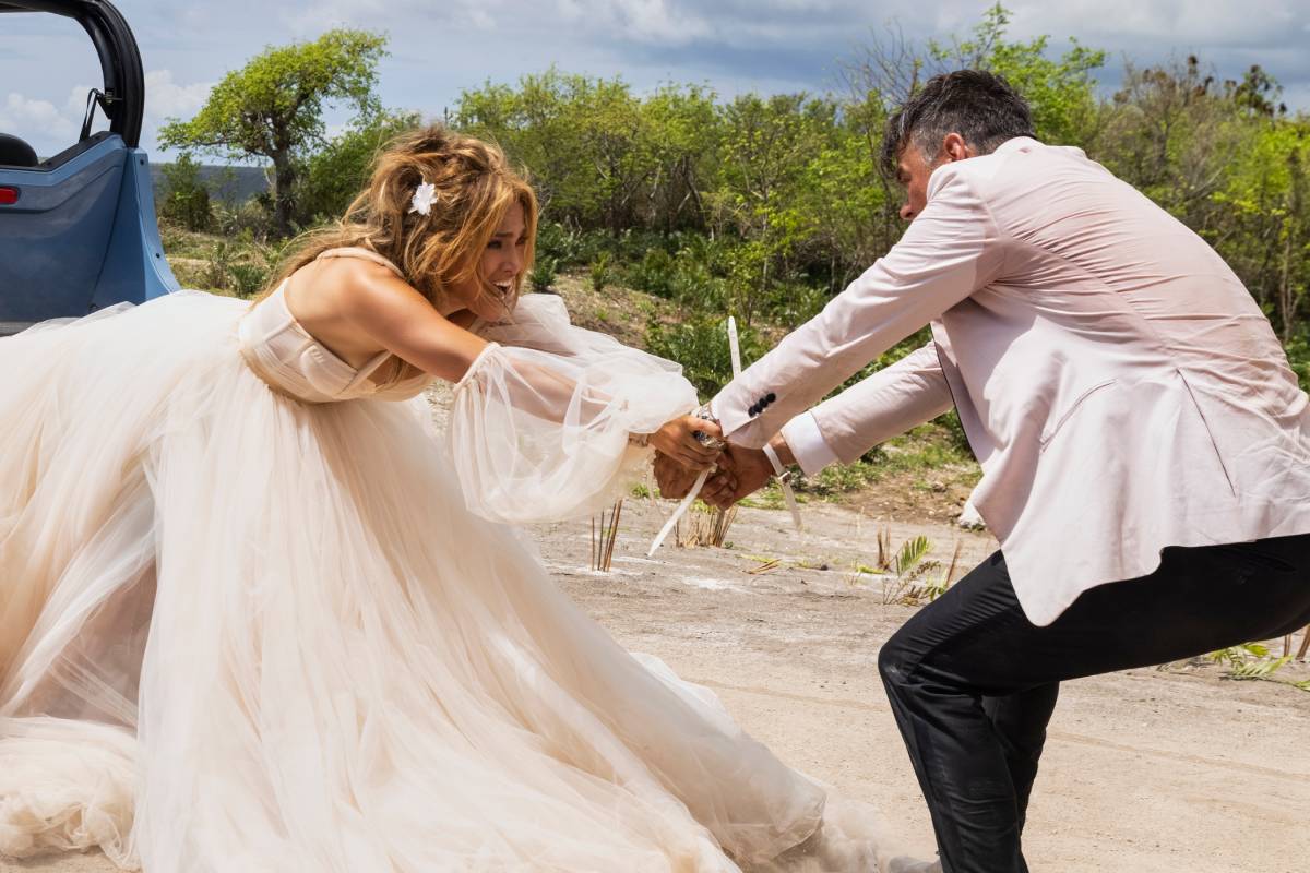 Darcy (Jennifer Lopez) e Tom (Josh Duhamel) com looks de casamento brigando pelo buqê de flores em Casamento Armado