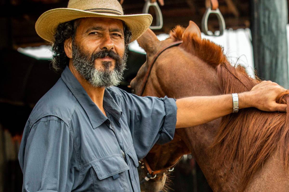 José Leôncio (Marcos Palmeira) posando com a mão em um cavalo em Pantanal