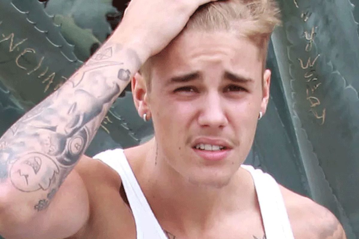 Justin Bieber com olhar preocupado e mão na cabeça