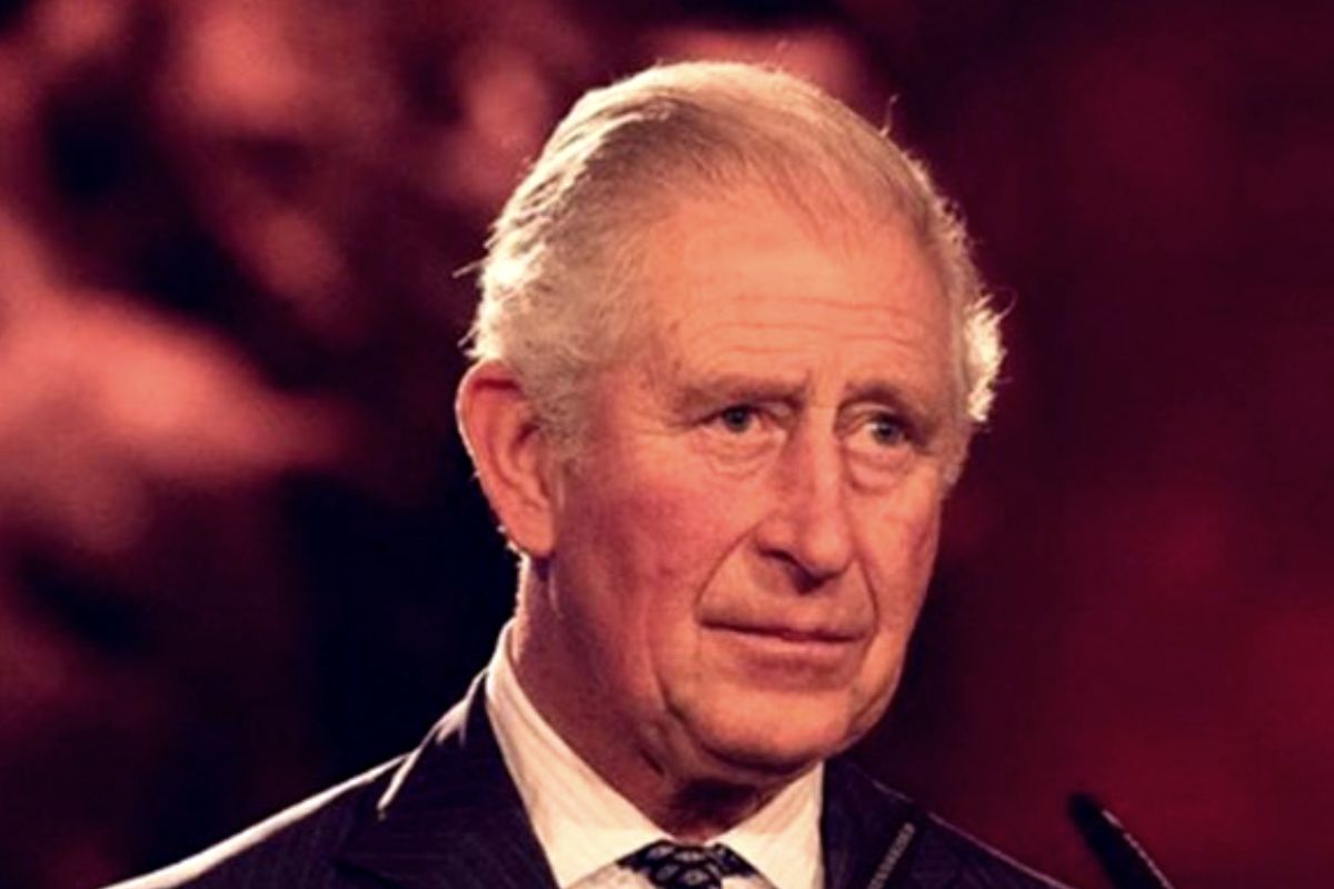 Príncipe Charles de terno e gravata, com olhar sério