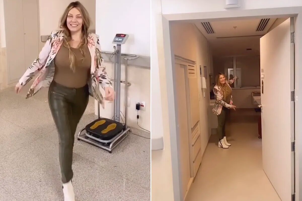 Simony de roupa marrom, andando no corredor do hospital, sorridente