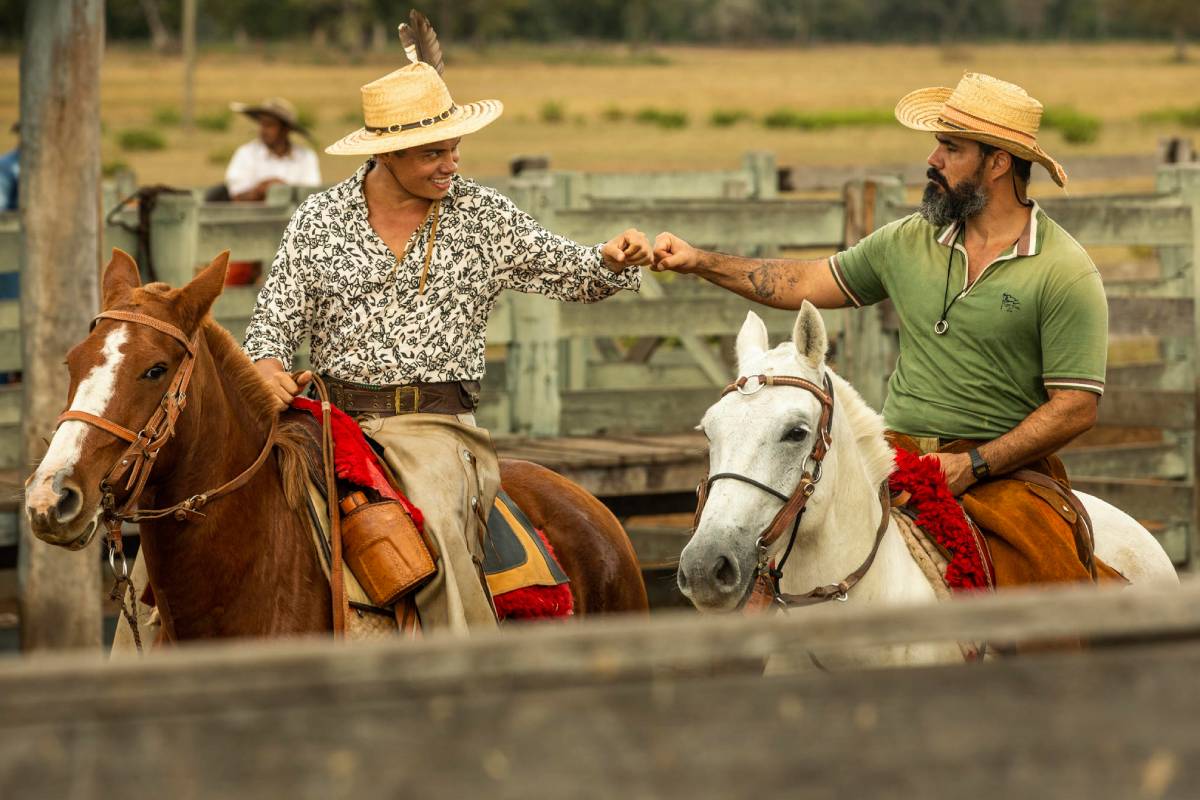 Alcides (Juliano Cazarré) e Zaquieu (Silvero Pereira) batendo punhos montados em seus cavalos em Pantanal