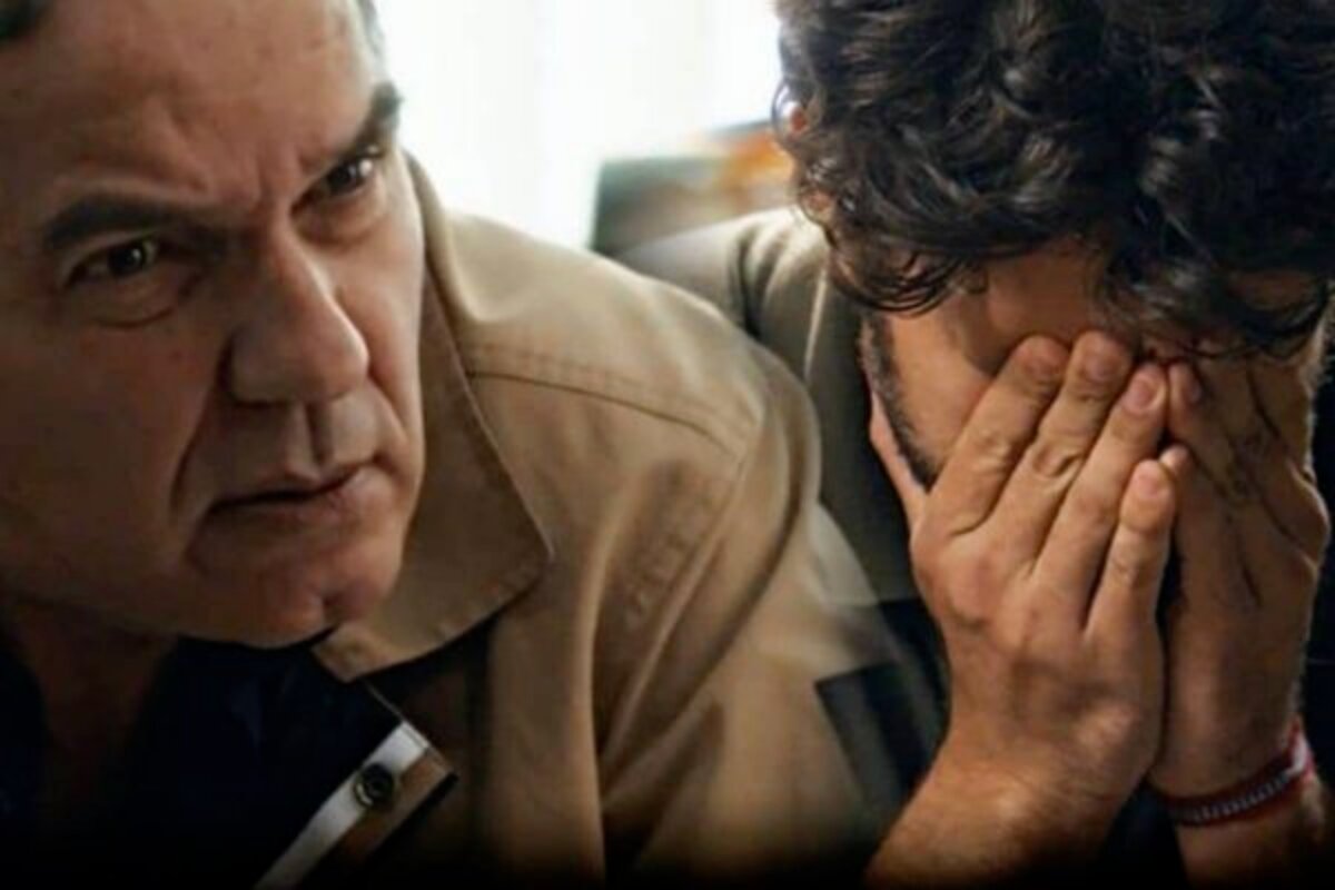 Guerra (Humberto Martins) olhando para Ari (Chay Suede), que está com as mãos no rosto em Travessia