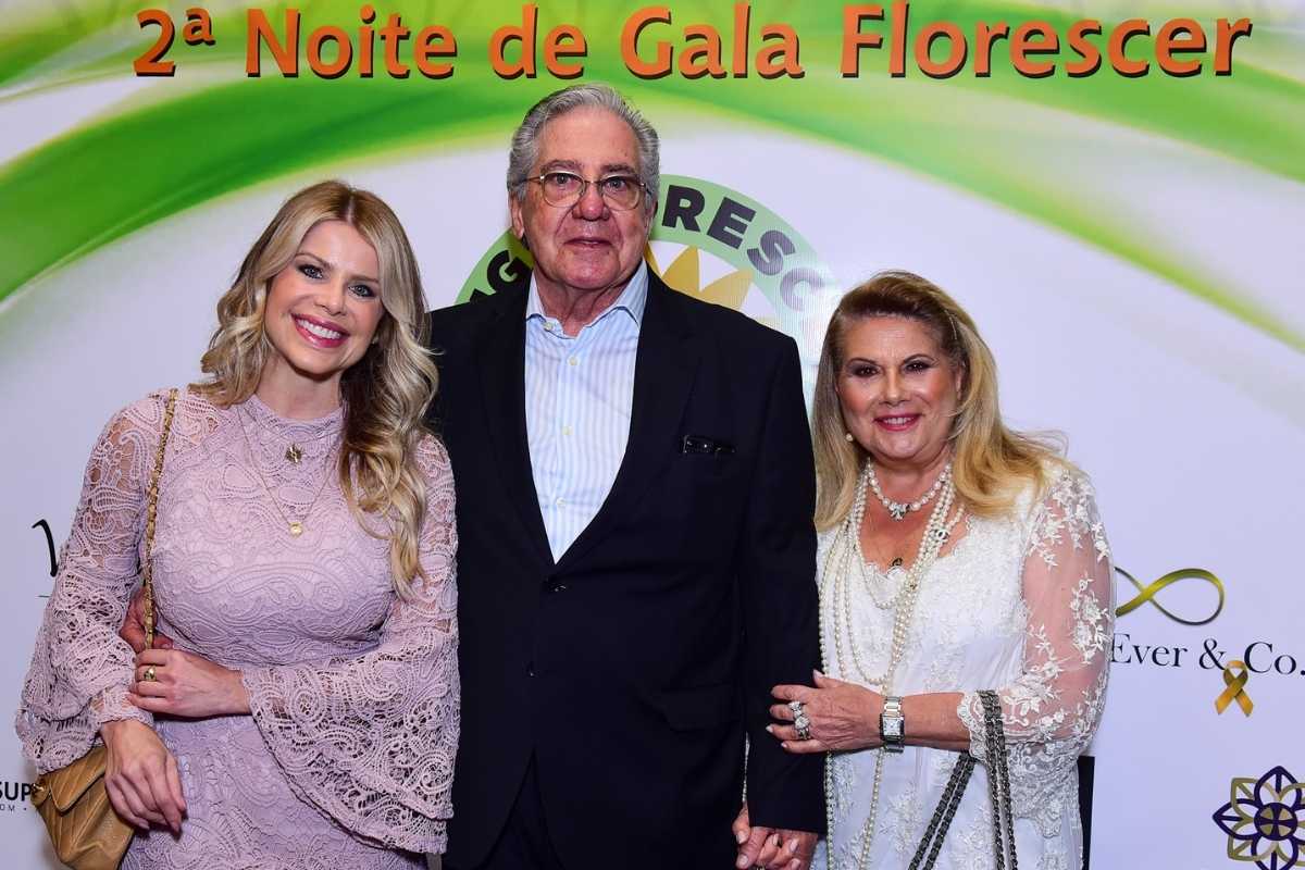 Karina Bacchi posando com os pais em evento da ONG Florescer