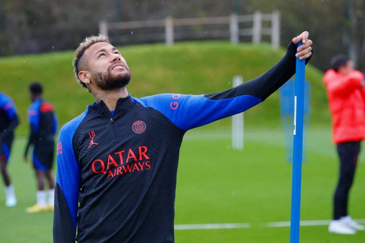 Neymar segurando em u bastão azul ed olhando para o céu com o uniforme do PSG