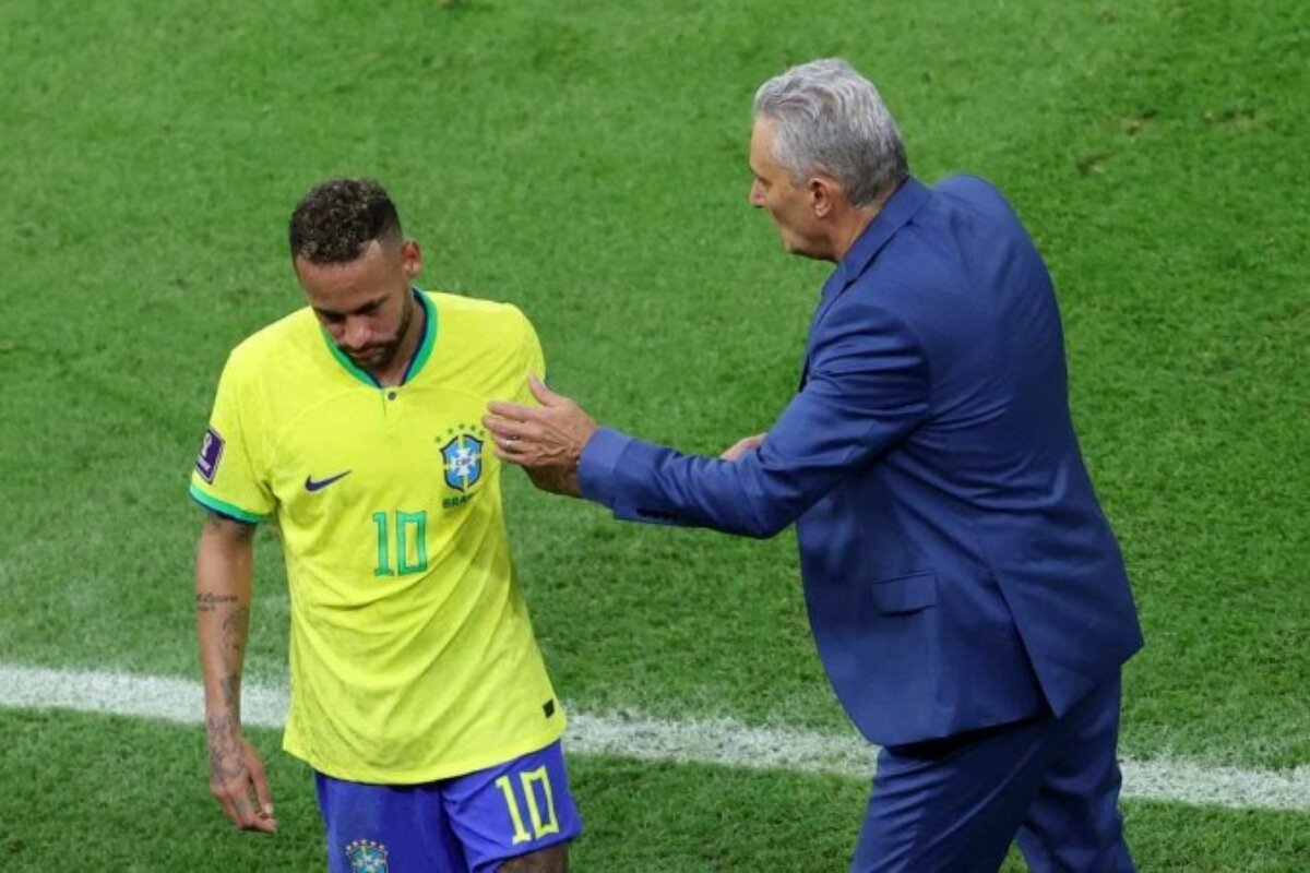 Neymar em campo, sendo consolado pelo técnico Tite