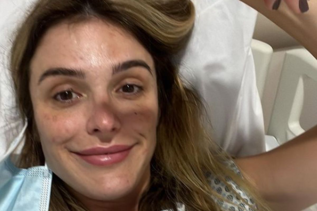 Rafa brites sorri, em cama de hospital, após cirurgia