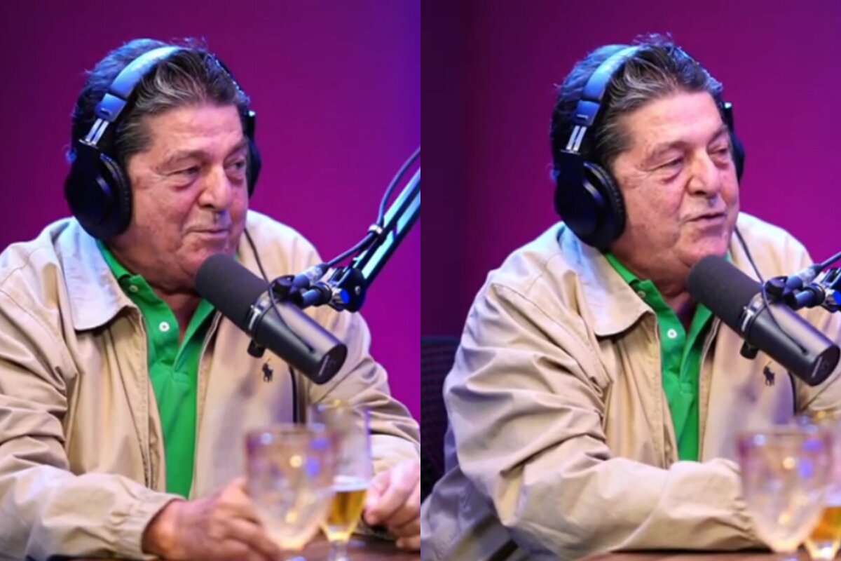 Stepan Nercessian de jaqueta bege e camisa verde, com fone de ouvido, falando ao microfone em estúdio de podcast