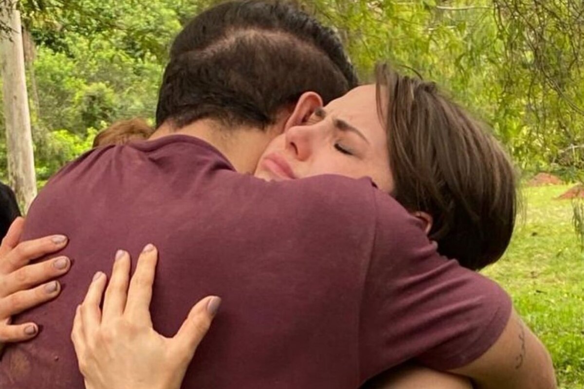 Caio Castro de costas abraçado a Letícia Colin, que está chorando