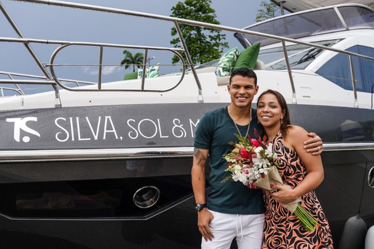 Thiago Silva com a esposa, Isabella e um buquê de flores, em frente a iate