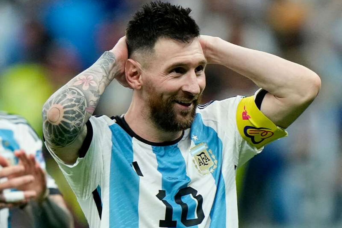 Lionel Messi com as mãos na cabeça, sorrindo, com a camisa da seleção argentina