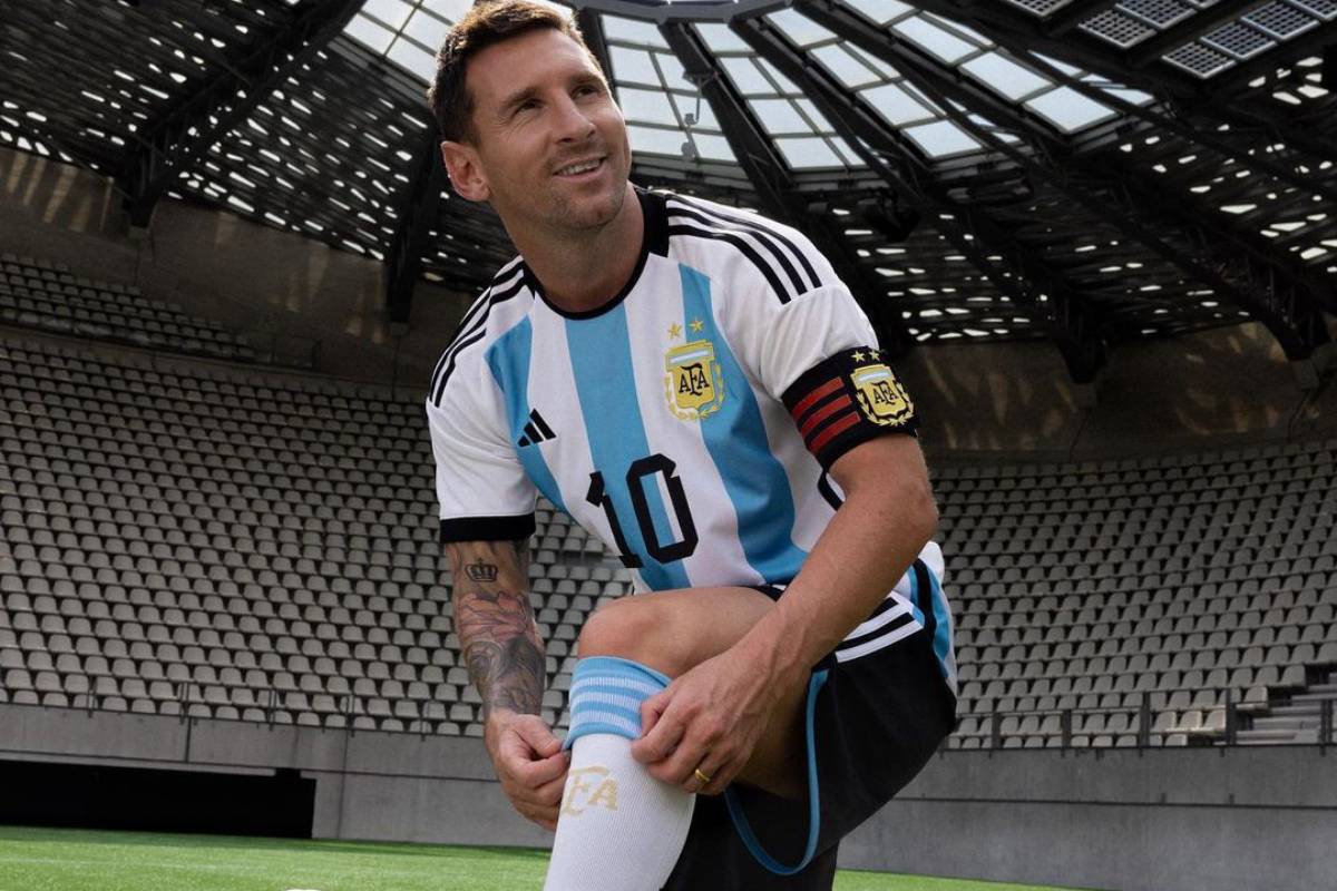 lionel messi com uniforme da argentina ajoelhado em campo