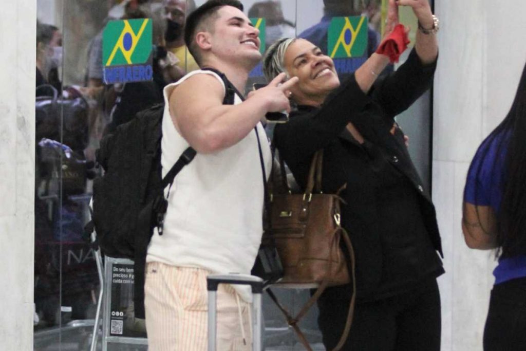 Lucas Souza tirando foto com fãs no aeroporto