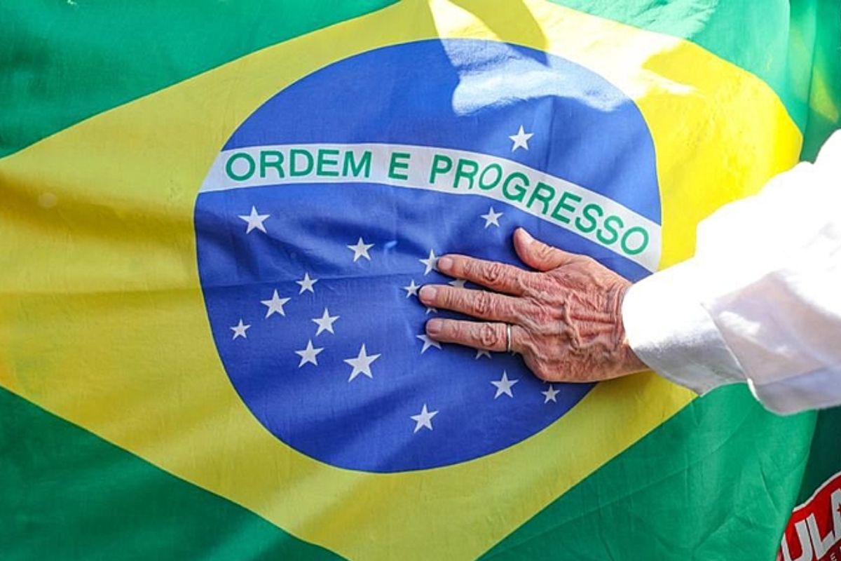 Bandeira do Brasil com a mão do presidente eleito, Luiz Inácio Lula da Silva