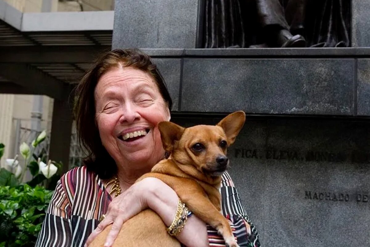 Nélida Piñon sorrindo com a cachorra de estimação no colo