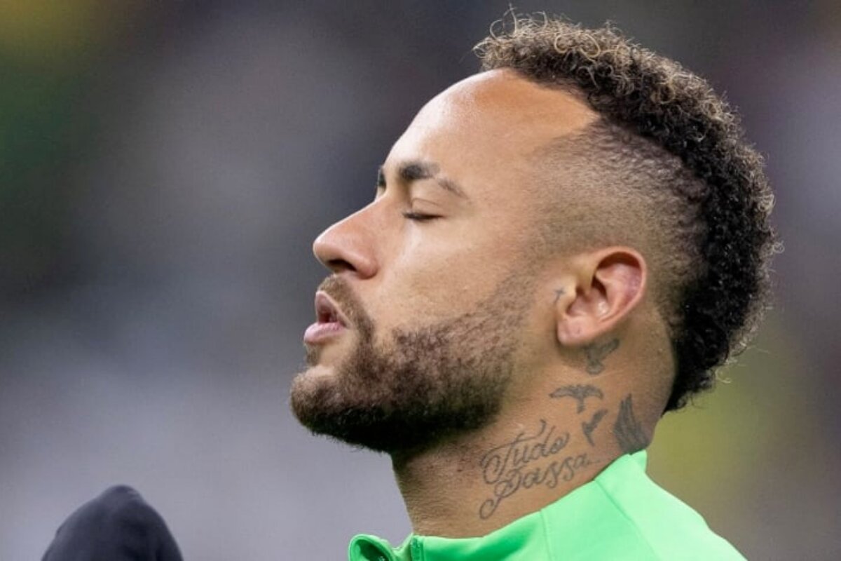 Neymar de olhos fechado, de perfil, camisa verde