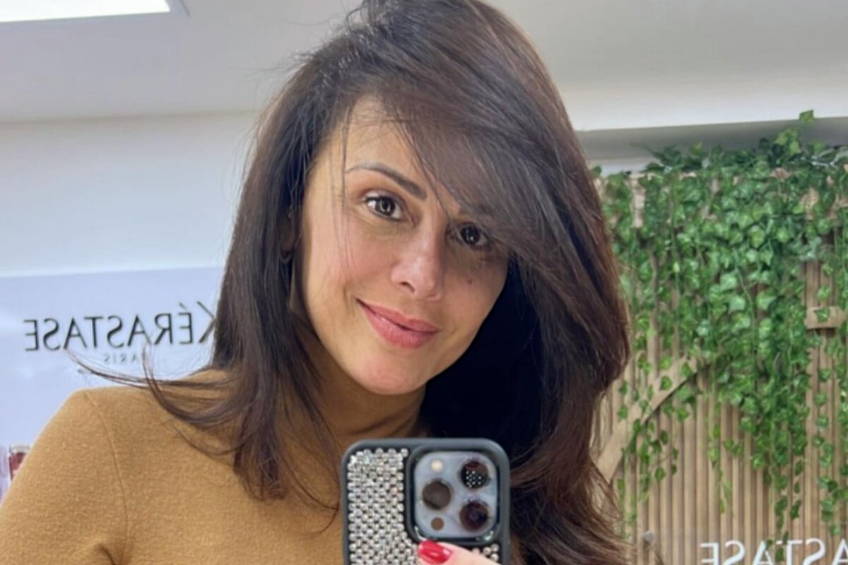 Viviane Araújo fazendo selfie, de blusa marrom de gola alta