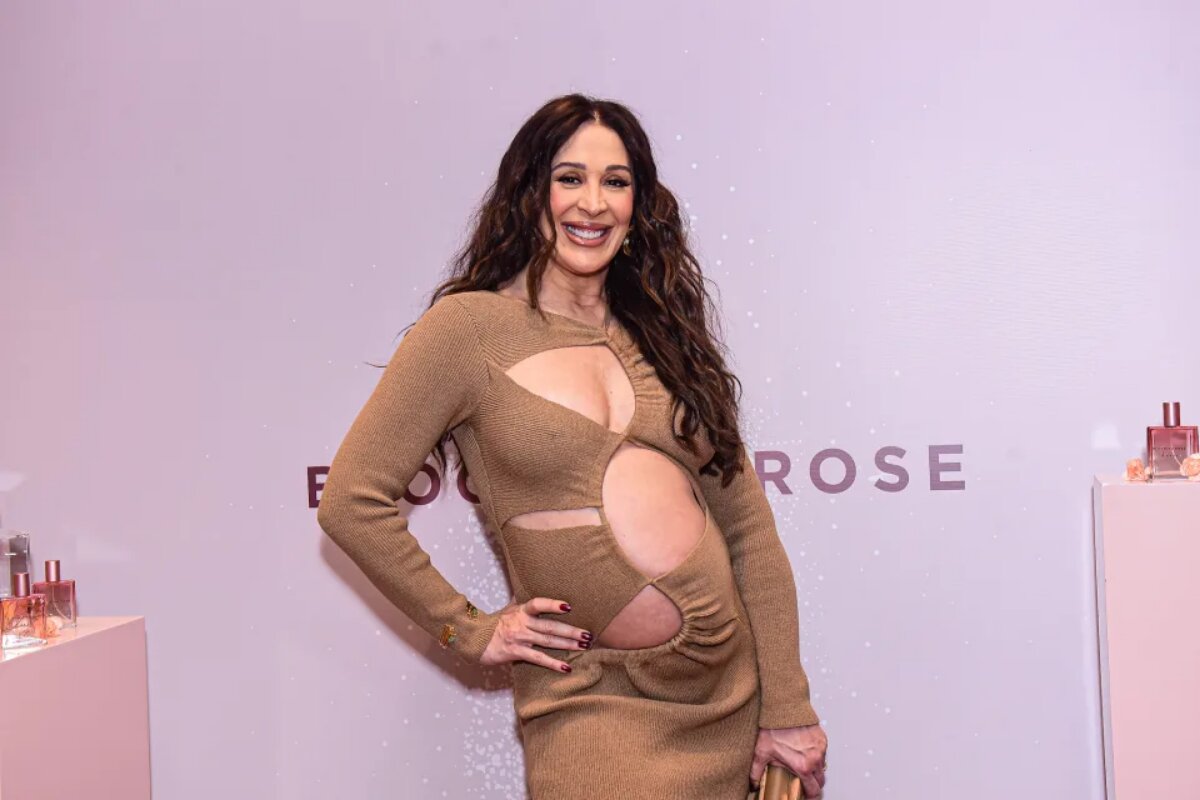 Claudia Raia de vestido marrom, de recortes, destacando a gravidez