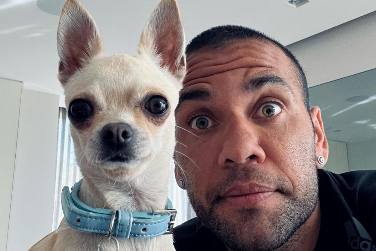 Daniel Alves com um cachorro branco, de coleira azul
