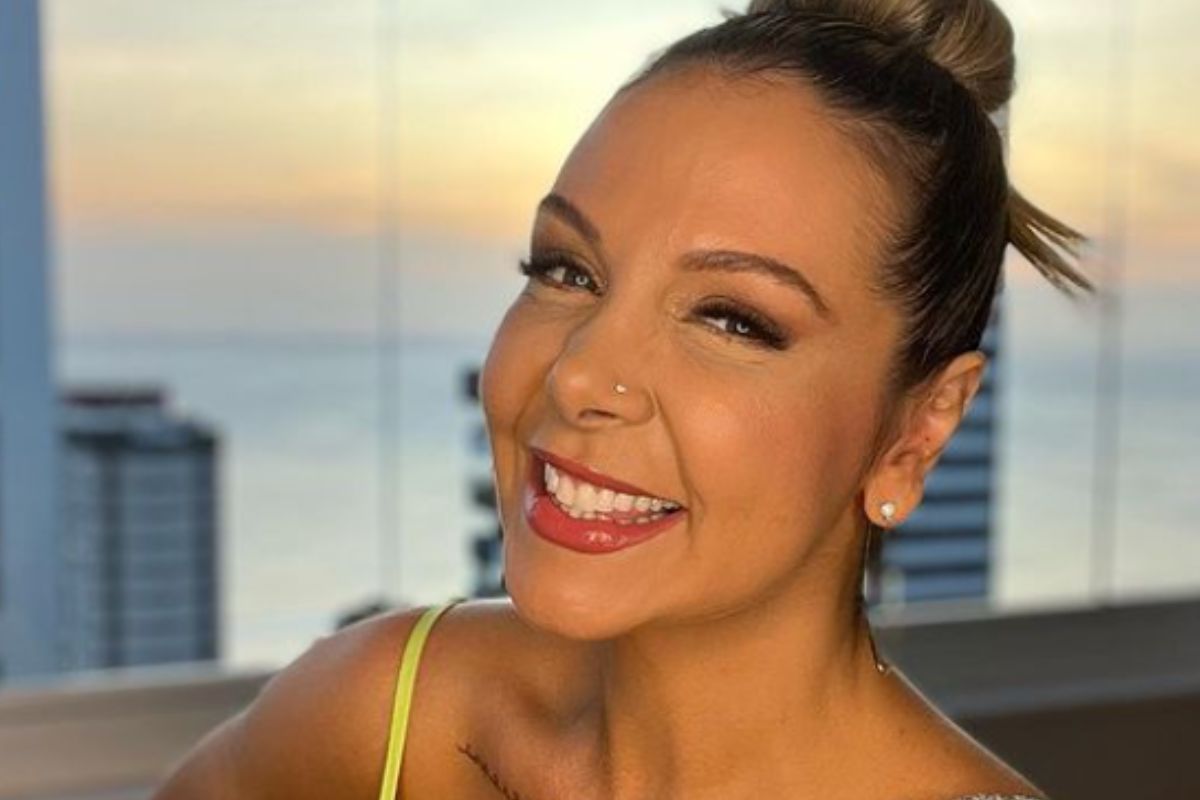 Carla Perez, sorridente, em uma selfie mostrando o pôr do sol de Salvador