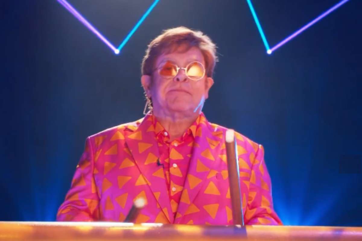Elton John usando um terno estampado de doritos