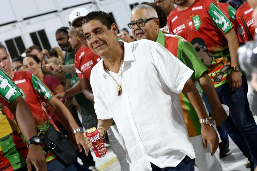 Zeca Pagodinho de camisa branca segurando lata de cerveja, no ensaio técnico da Grande Rio na Sapucaí 