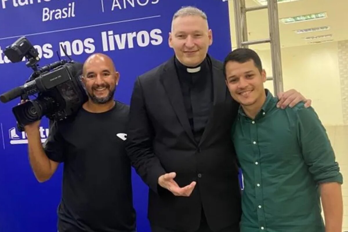 Cinegrafista, padre Marcelo Rossi e repórter João Britto, da TV Gazeta, abraçados