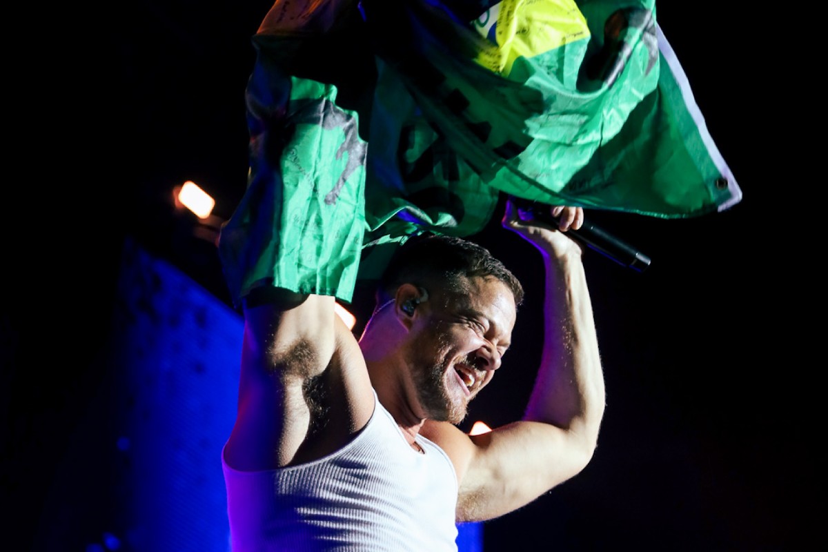 dan reynolds, vocalista do imagine dragons, segurando bandeira do brasil em show da banda em são paulo