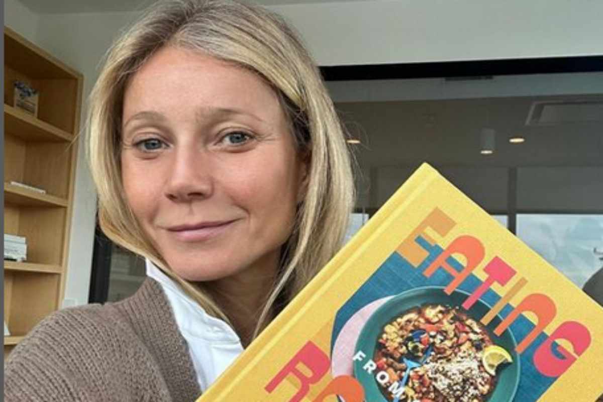 Gwyneth Paltrow com livro sobre comida, nas mãos