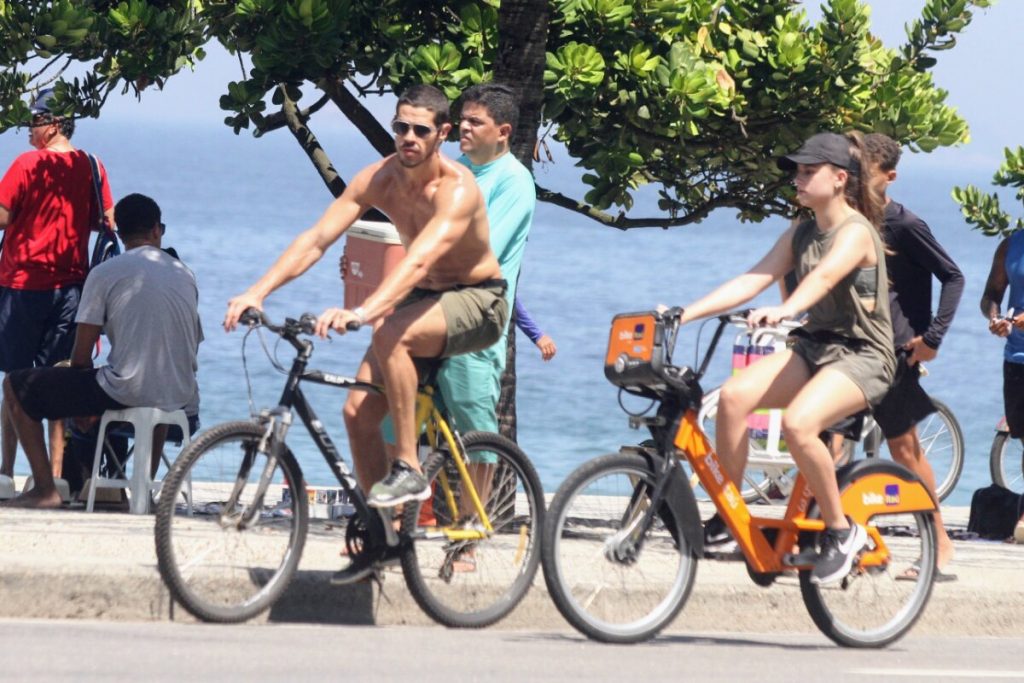 José Loreto sem camisa, andando de bicicleta na orla