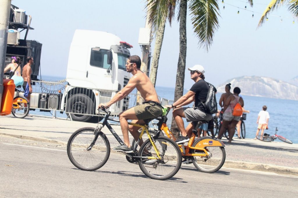 José Loreto sem camisa, andando de bicicleta na orla