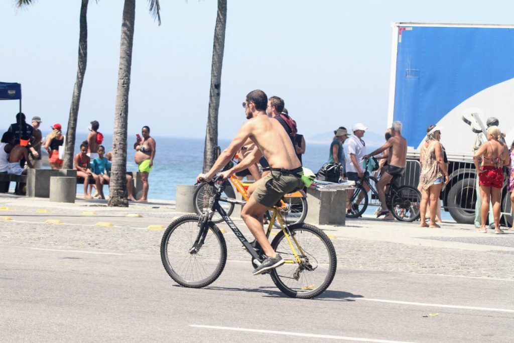 José Loreto sem camisa, andando de bicicleta na orla