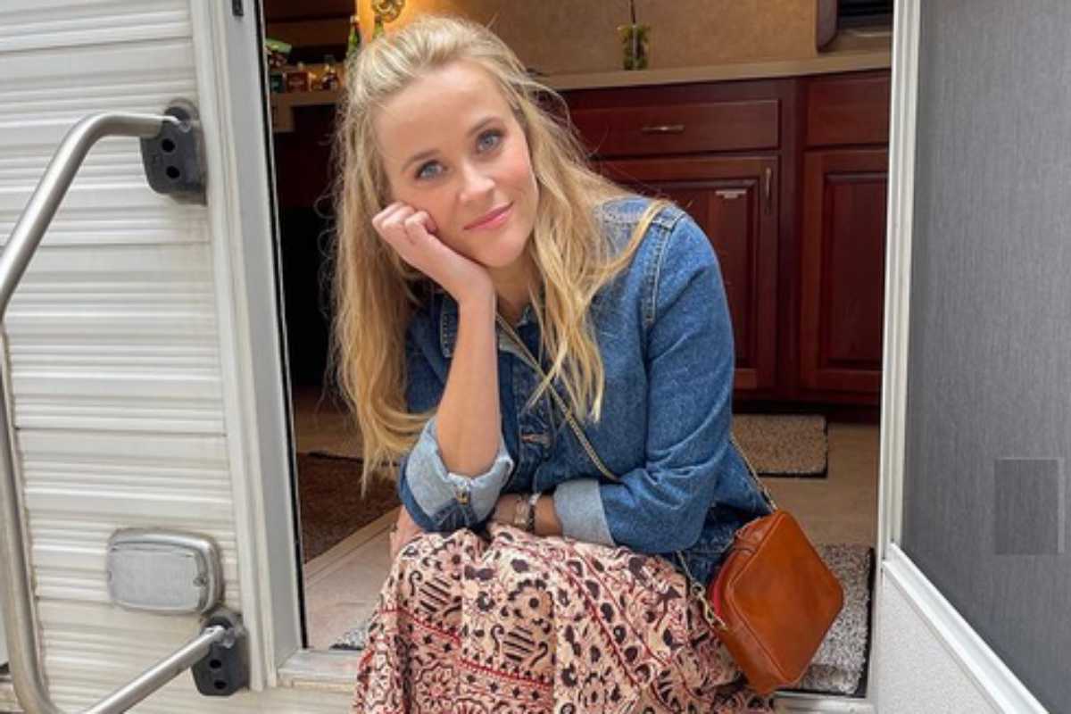 Reese Witherspon sentada na porta de trailer