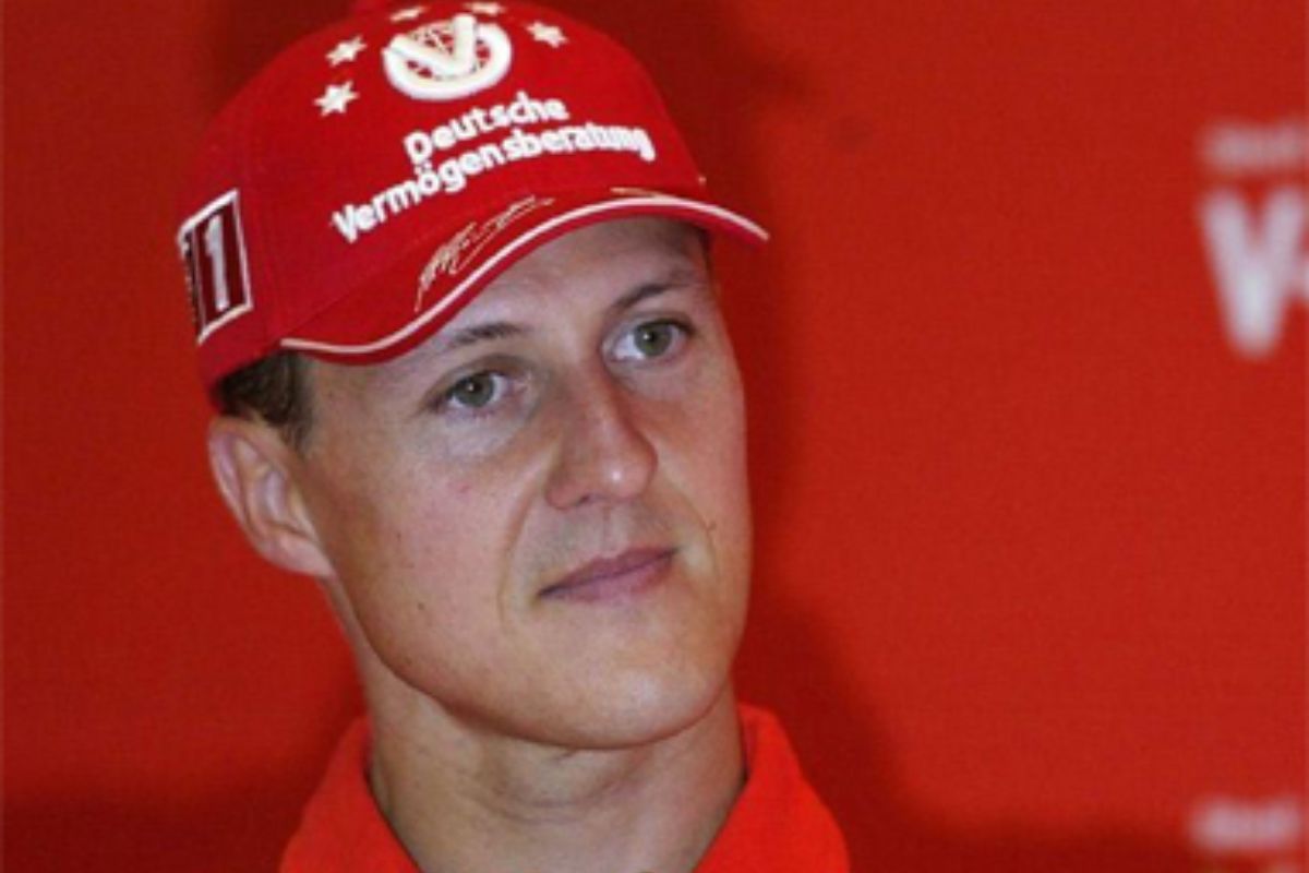 Michael Schumacher, com olhar sério, de boné vermelho