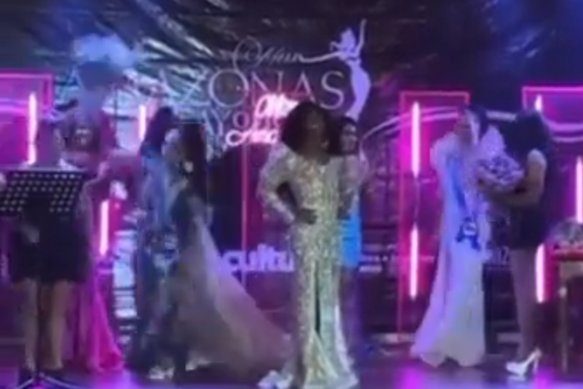 modelo batendo com buquê de flores em organizadora do concurso miss gay amazonas