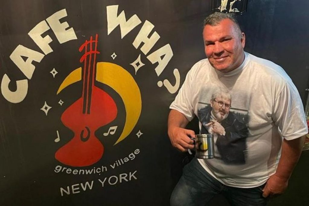 Roberto Trevisan na entrada do Café Wha?, com caneca em homenagem a Jô Soares