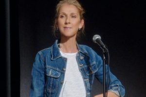 celine dion concentrada no palco com microfone