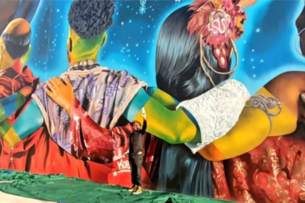 Eduardo Kobra bem pertinho do novo mural em Benin, África