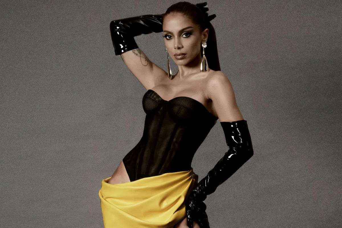 Anitta posando estilosa com look preto e amarelo