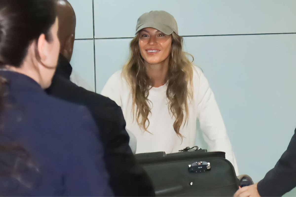Gisele Bündchen sorridente em aeroporto