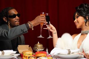 Offset e Cardi B brindando sentados à mesa