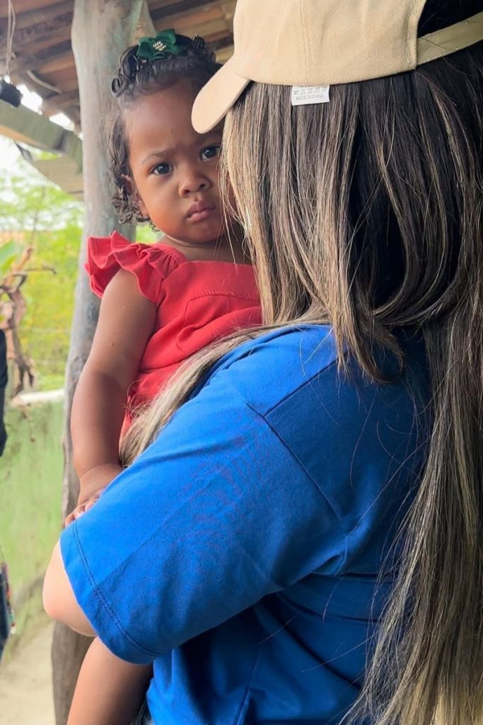 Amanda Meirelles segura uma menininha no colo 