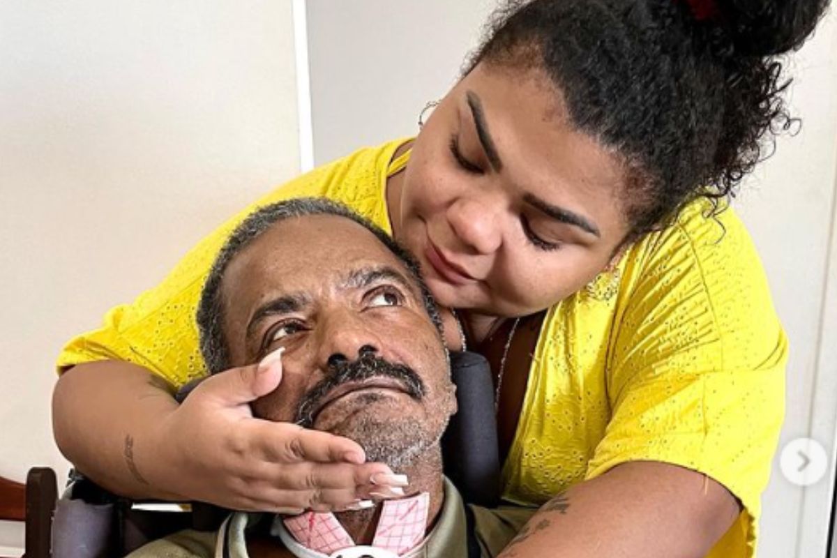 Flora Cruz acaricia o rosto do pai, Arlindo Cruz, após alta hospitalar