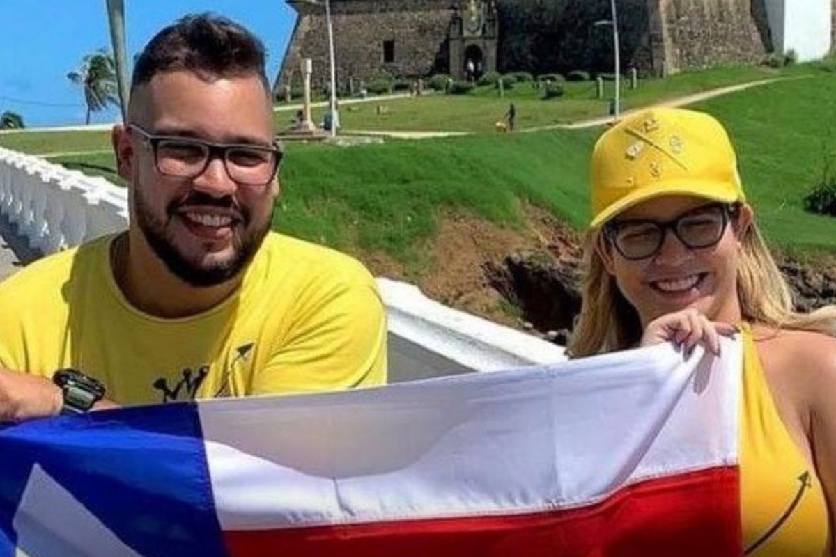 henrique ribeiro e marília mendonça segurando bandeira da bahia